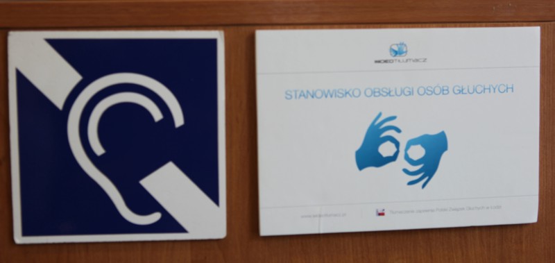 Specjalny znak do obsługi osób głuchych umieszczony na drzwiach biura.